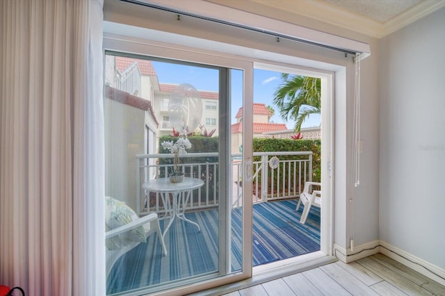 doorway featuring ornamental molding and light hardwood / wood-style flooring