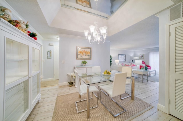 dining area featuring ornamental molding, a notable chandelier, and light hardwood / wood-style flooring