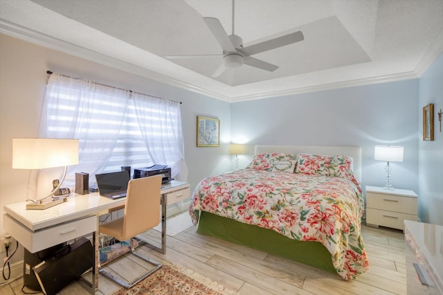 bedroom with ceiling fan, crown molding, light hardwood / wood-style floors, and a raised ceiling