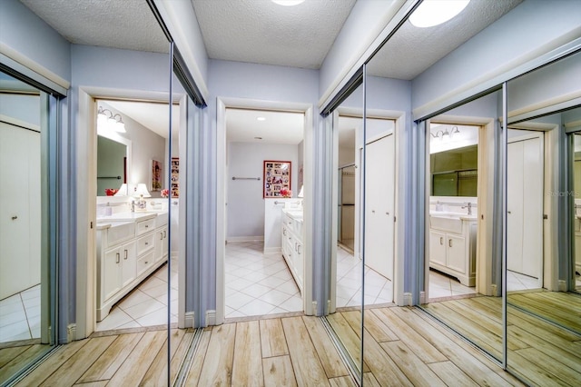 bathroom with a textured ceiling, tile flooring, and vanity