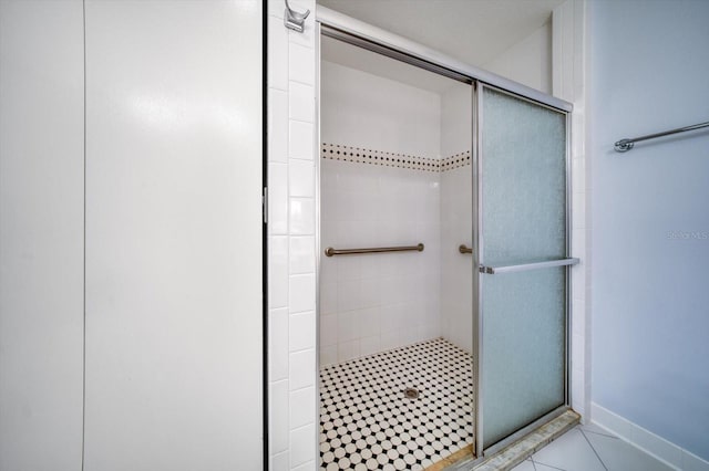 bathroom with tile floors and a shower with shower door