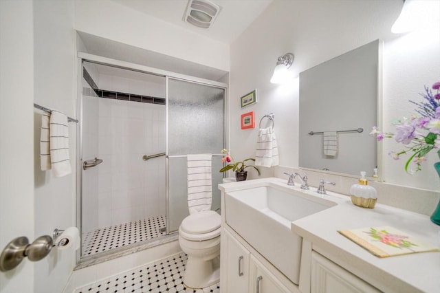 bathroom with tile flooring, a shower with shower door, large vanity, and toilet