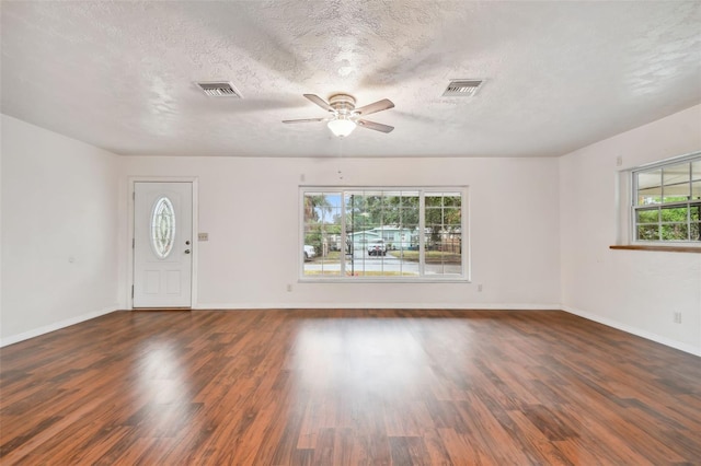 entrance foyer with a textured ceiling, dark wood-type flooring, ceiling fan, and a healthy amount of sunlight