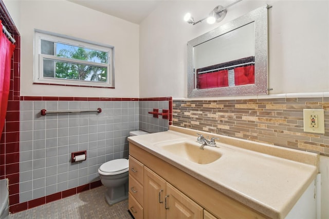 bathroom featuring tile patterned flooring, vanity, tile walls, and toilet