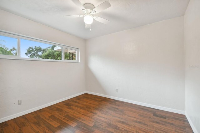 unfurnished room with ceiling fan and dark hardwood / wood-style flooring