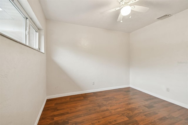 empty room with ceiling fan and dark hardwood / wood-style flooring