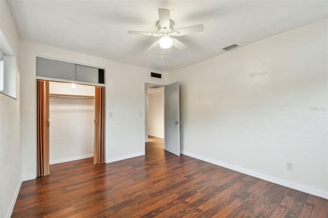 unfurnished bedroom with ceiling fan, dark hardwood / wood-style floors, and a closet