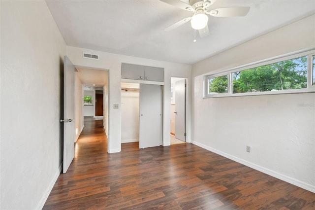 unfurnished bedroom featuring ceiling fan and dark wood-type flooring