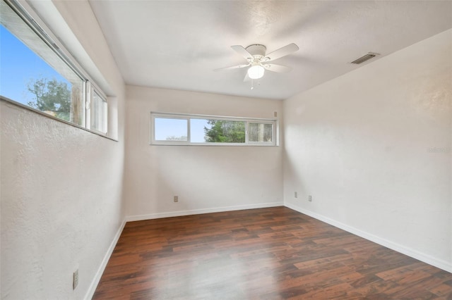 empty room with ceiling fan and dark wood-type flooring