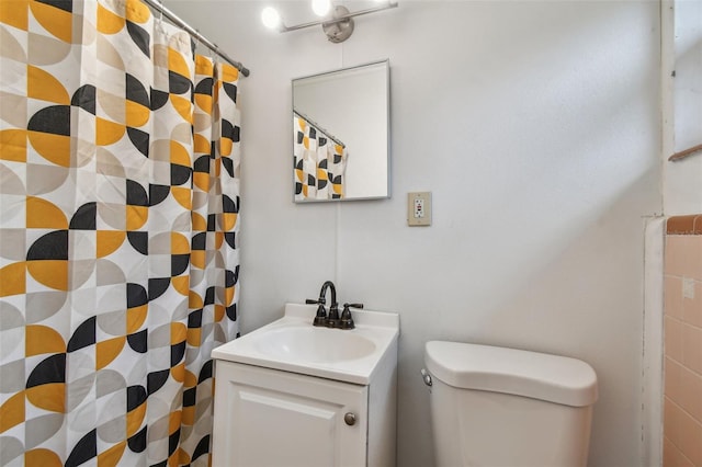 bathroom featuring curtained shower, vanity, and toilet