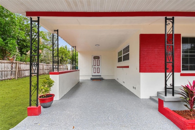 entrance to property featuring a porch and a lawn