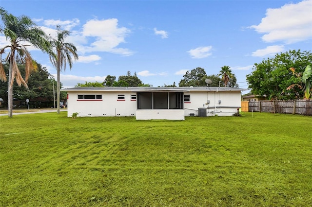 rear view of property with a sunroom, a yard, and cooling unit