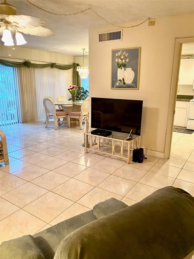 living area featuring visible vents, a textured ceiling, and light tile patterned floors