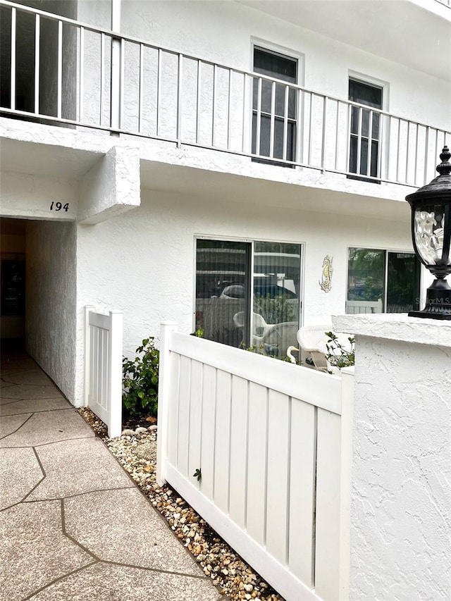 view of home's exterior with board and batten siding, fence, and stucco siding