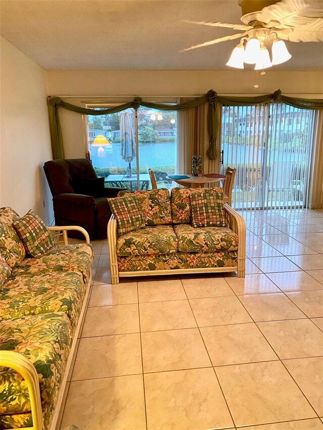 living area featuring light tile patterned floors and a ceiling fan