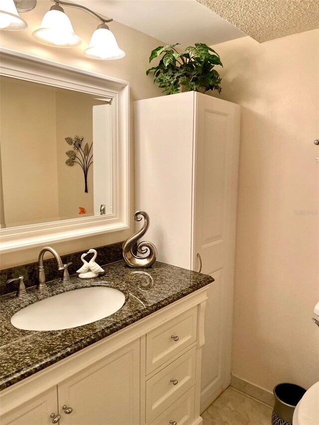 bathroom featuring tile patterned flooring, vanity, and baseboards