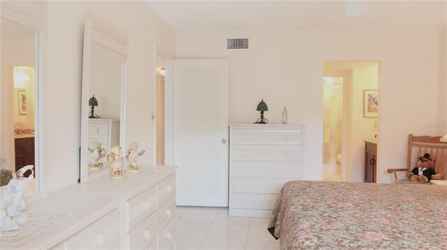 bedroom featuring light tile patterned floors, visible vents, and ensuite bathroom