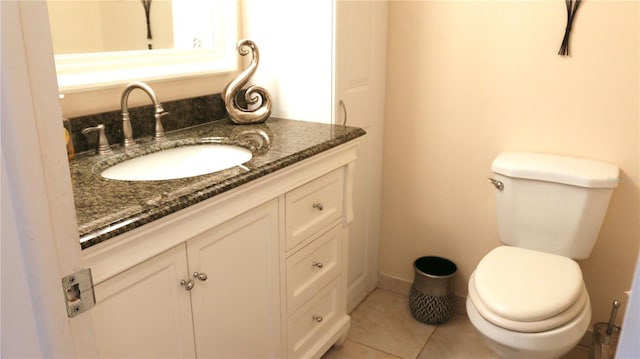 bathroom with toilet, tile patterned flooring, and vanity