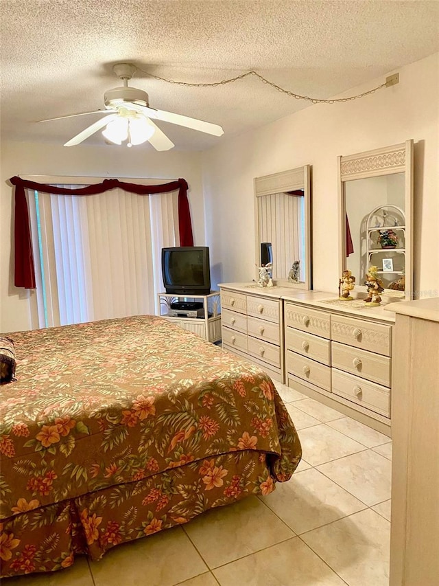 bedroom featuring a textured ceiling, ceiling fan, and light tile patterned flooring