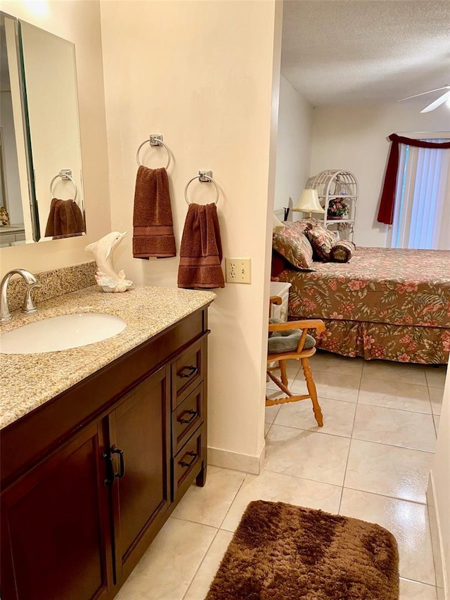 bathroom featuring a textured ceiling, baseboards, vanity, and tile patterned floors