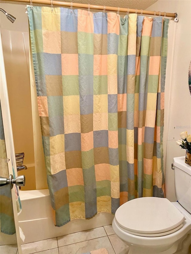 bathroom featuring toilet, shower / bath combo with shower curtain, and tile patterned floors