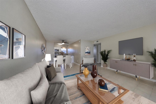 living room with a textured ceiling and ceiling fan