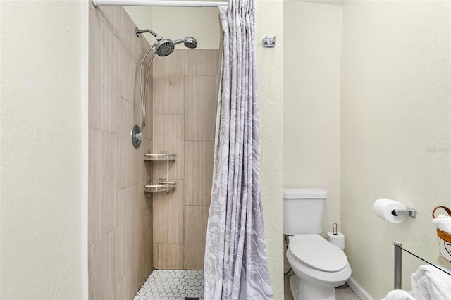 bathroom featuring a stall shower and toilet