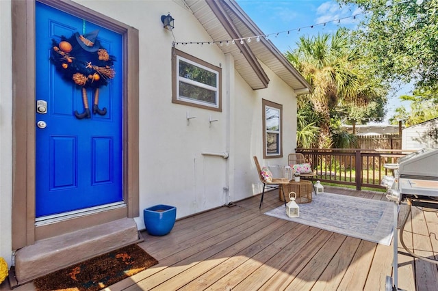 entrance to property with fence and stucco siding