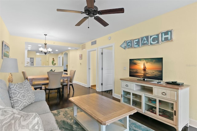 living room featuring ceiling fan with notable chandelier and dark hardwood / wood-style floors