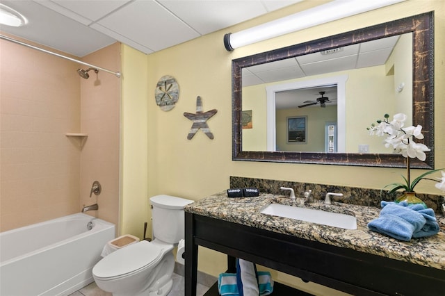 full bathroom featuring vanity, tiled shower / bath combo, toilet, and ceiling fan