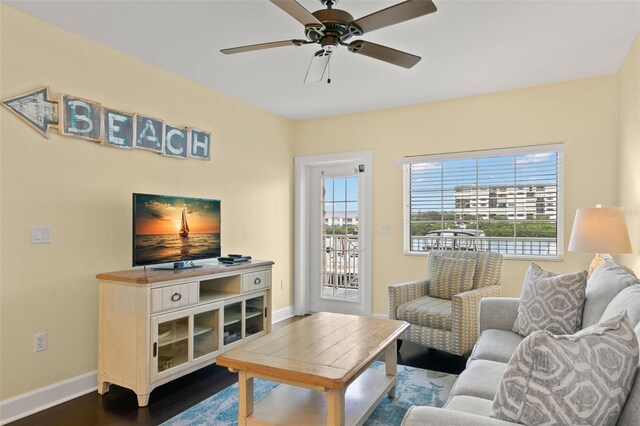 living room with ceiling fan and dark hardwood / wood-style flooring