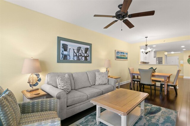 living room with dark hardwood / wood-style floors and ceiling fan with notable chandelier