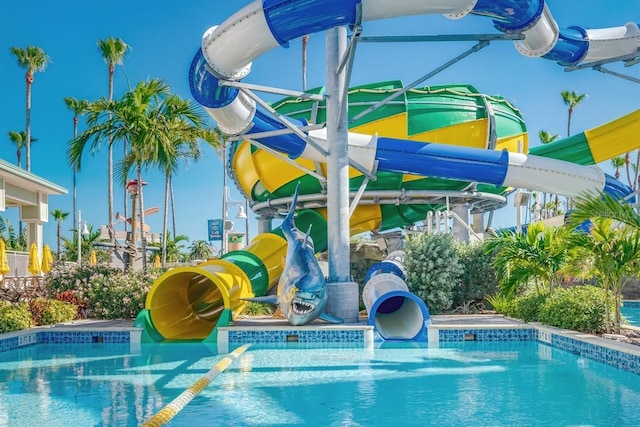 pool with a water slide and a water play area