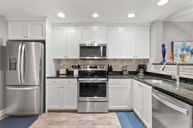 kitchen featuring appliances with stainless steel finishes, white cabinetry, and sink