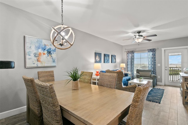 dining space with hardwood / wood-style floors and ceiling fan with notable chandelier