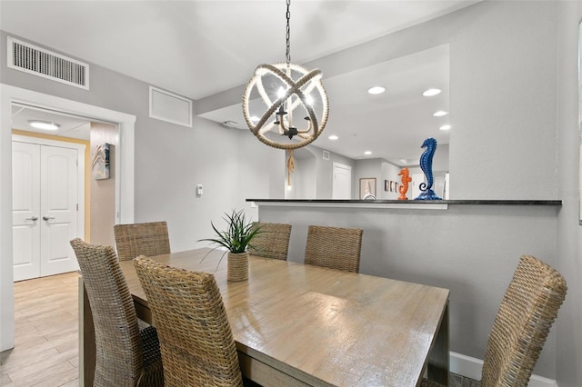 dining area featuring light hardwood / wood-style floors and a notable chandelier