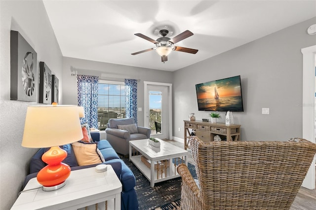 living area featuring a ceiling fan and baseboards