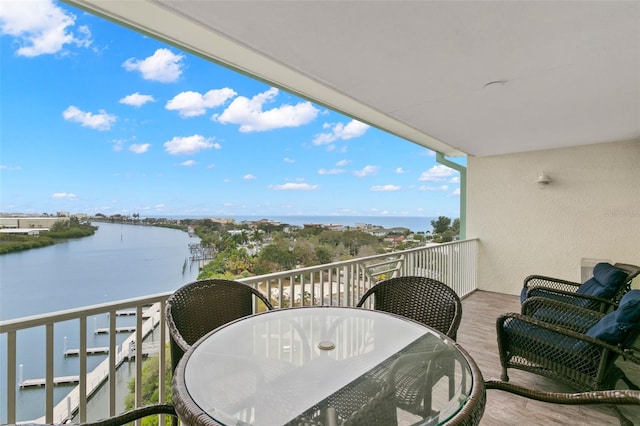 balcony with a water view and outdoor dining space