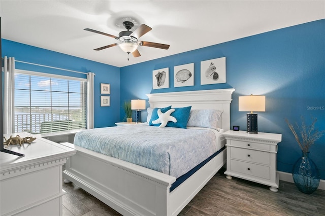 bedroom with dark wood finished floors, a ceiling fan, and baseboards