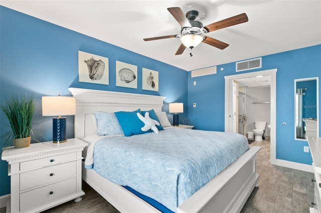 bedroom with visible vents, a ceiling fan, ensuite bath, wood finished floors, and baseboards