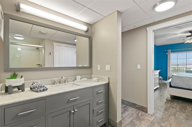 bathroom with an enclosed shower, vanity, a drop ceiling, and ceiling fan