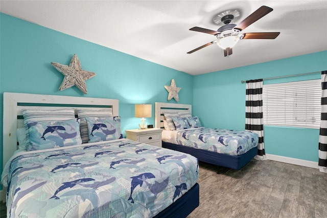 bedroom featuring ceiling fan, baseboards, and wood finished floors