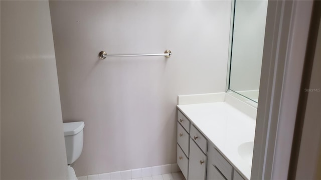 bathroom featuring tile flooring, vanity, and toilet