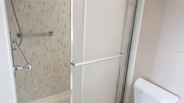 bathroom with an enclosed shower and toilet