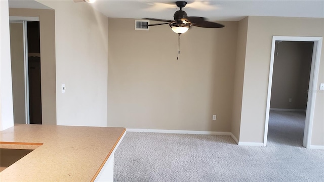 unfurnished dining area featuring carpet and ceiling fan