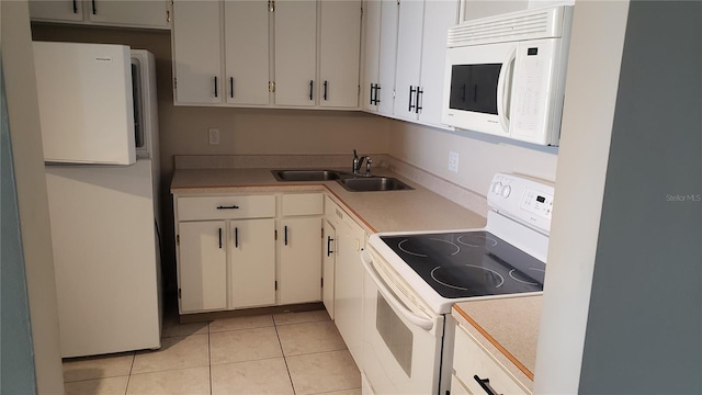 kitchen with white appliances, sink, white cabinetry, and light tile floors