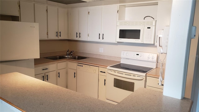 kitchen featuring sink, white appliances, and white cabinetry