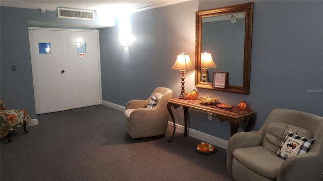 sitting room featuring ornamental molding and carpet flooring