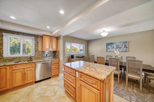 kitchen with tasteful backsplash, light stone counters, dishwasher, and a center island