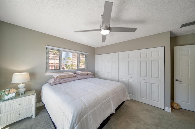 bedroom featuring a textured ceiling, carpet floors, a closet, and ceiling fan